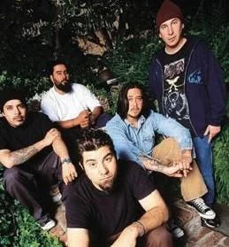 Deftones posing outdoors in band tees and oversized work pants