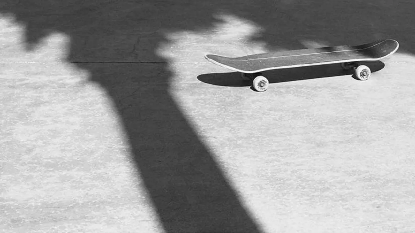 Black skateboard casting a long shadow across sunlit concrete, a nod to Palm Angels' skate-culture roots