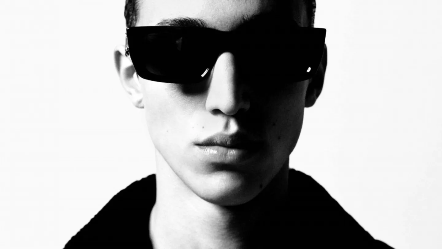 Close-up black-and-white portrait of a model in rectangular black sunglasses from a Palm Angels campaign