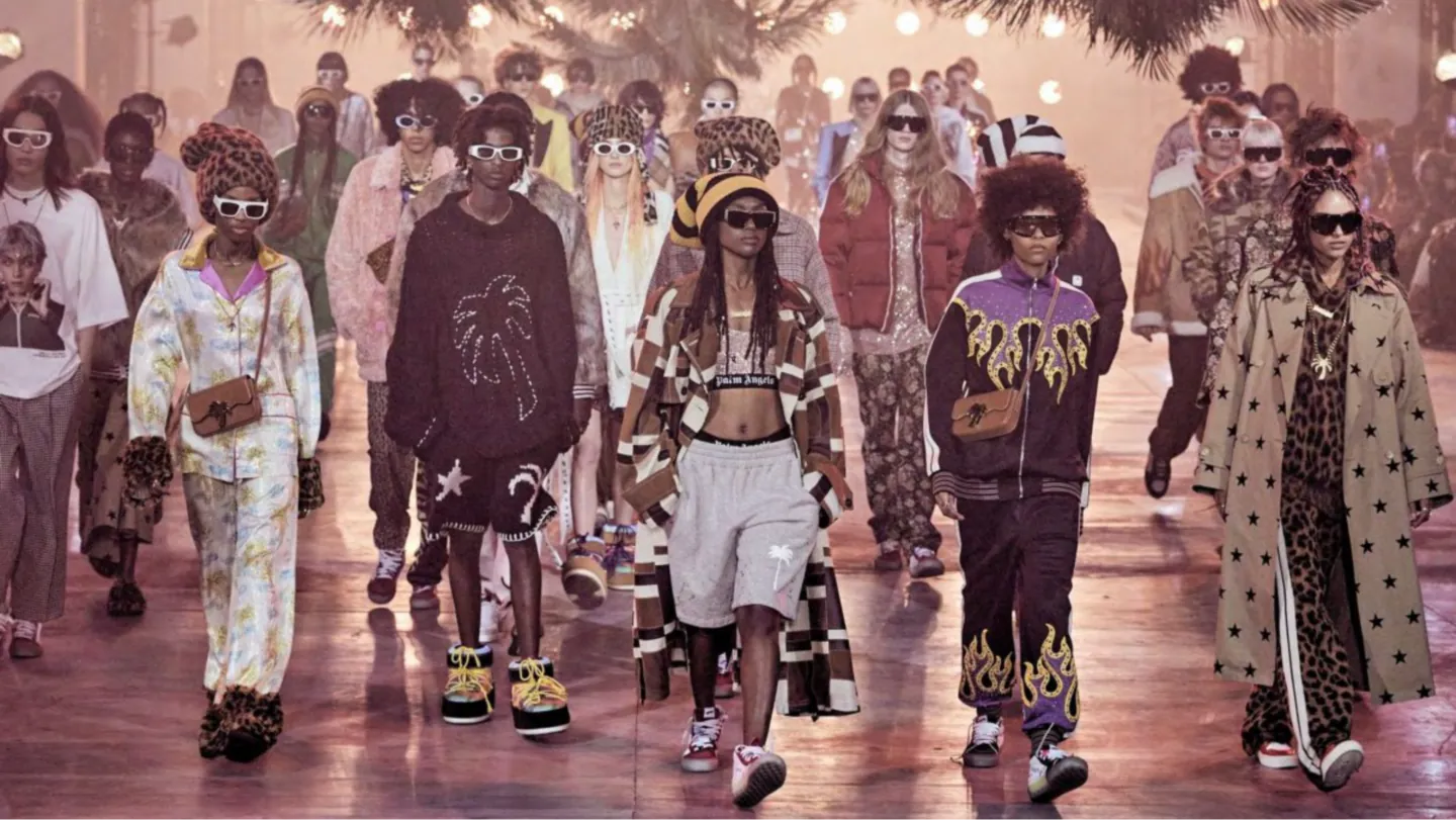 Models in layered Palm Angels streetwear, from flame-print track jackets to star-print coats, on the runway
